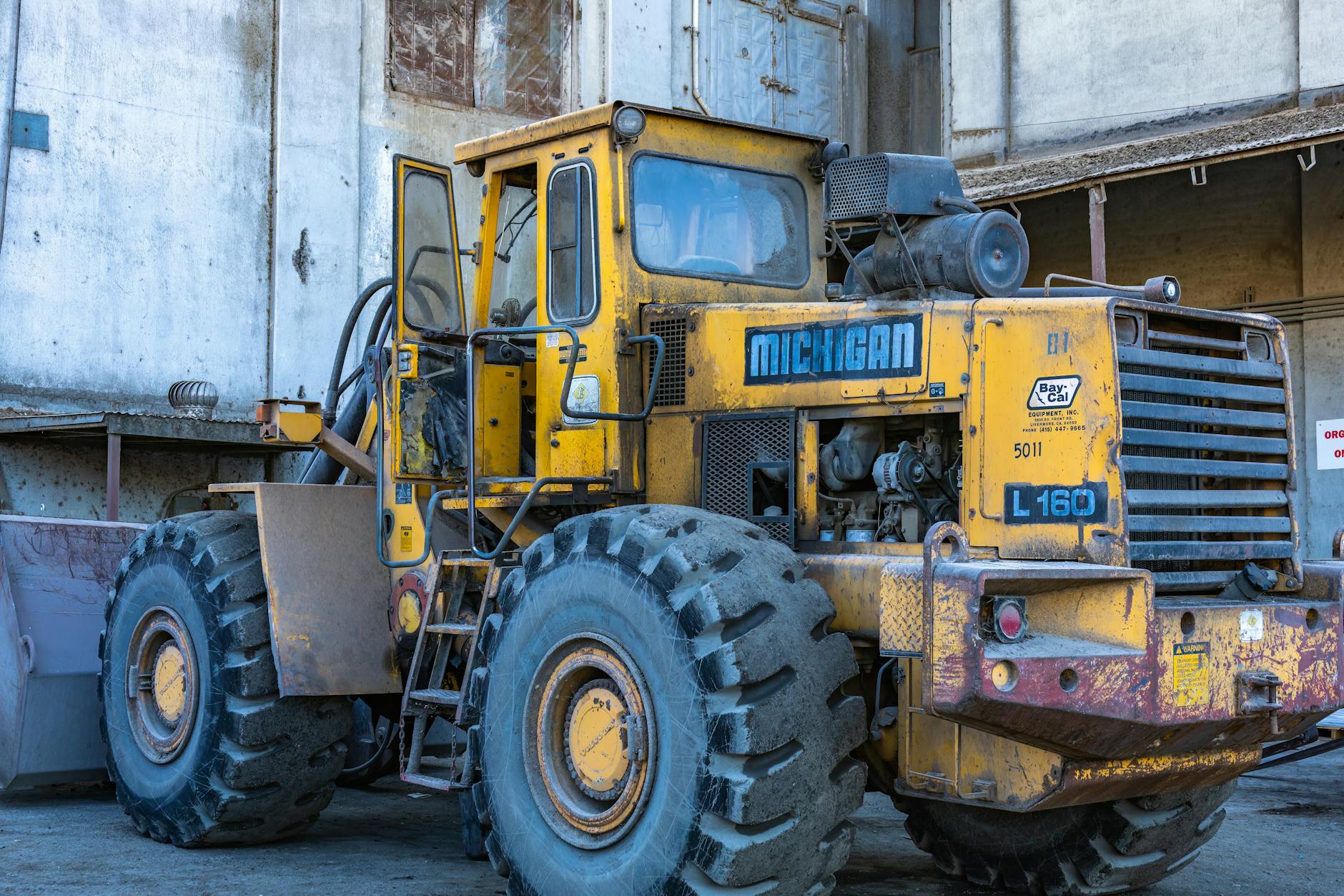 Ładowarka kołowa przy magazynie podczas pracy na placu