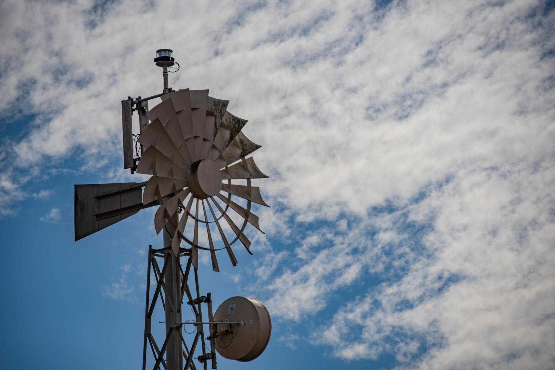 Stara wiatrakowa turbina na tle jasnego, bezchmurnego nieba