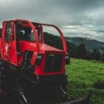 Opony rolnicze: ciśnienie, uciąg i zużycie paliwa Czerwony traktor na zielonym polu pod pochmurnym niebem