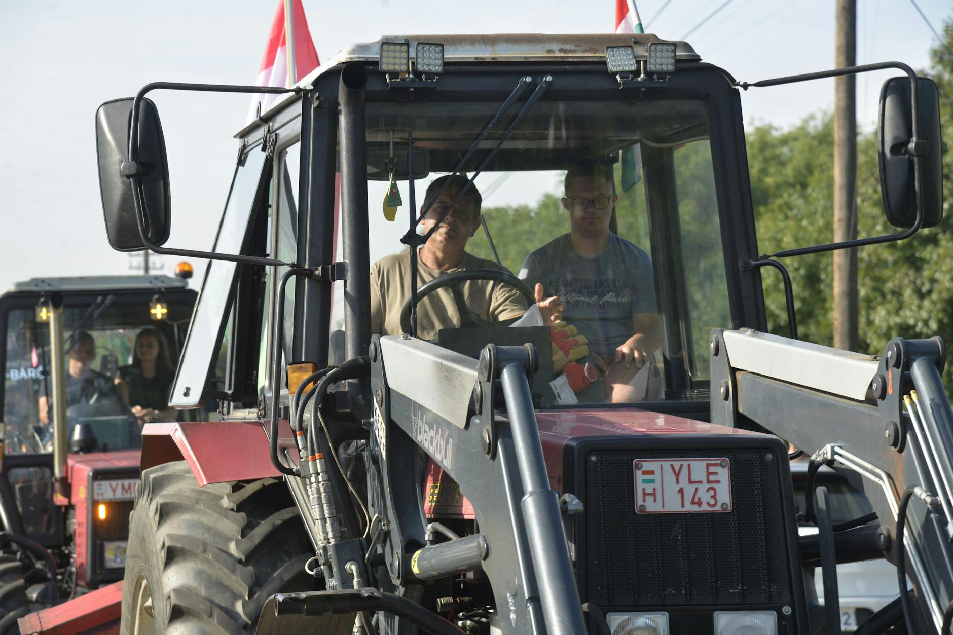 Rolnicy pracujący ciągnikami na polu w słoneczny dzień