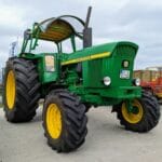Zielony ciągnik John Deere z dużymi oponami na placu w niemieckiej wsi