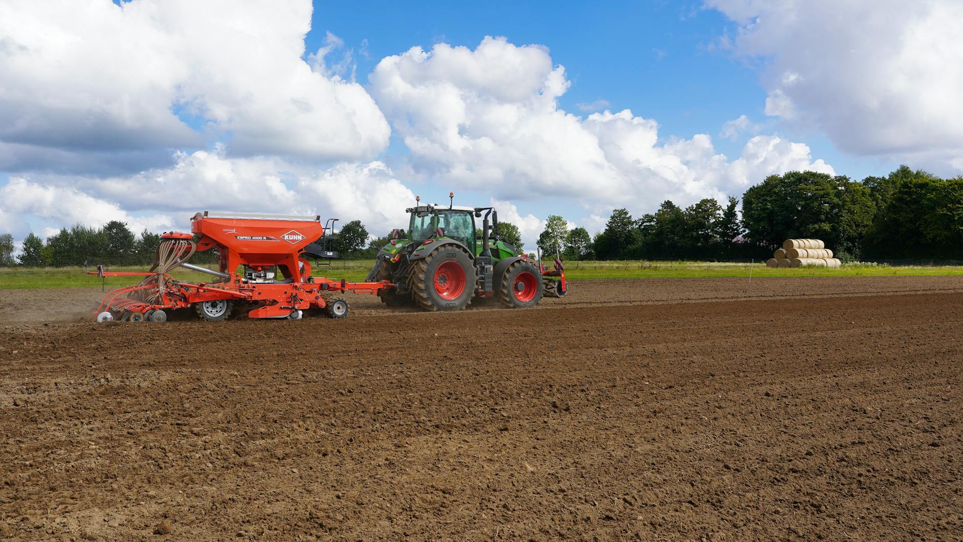 Ciągnik z siewnikiem wykonuje siew bezorkowy na polu