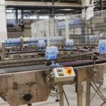 Butelki z wodą na zautomatyzowanej linii w nowoczesnej przetwórni